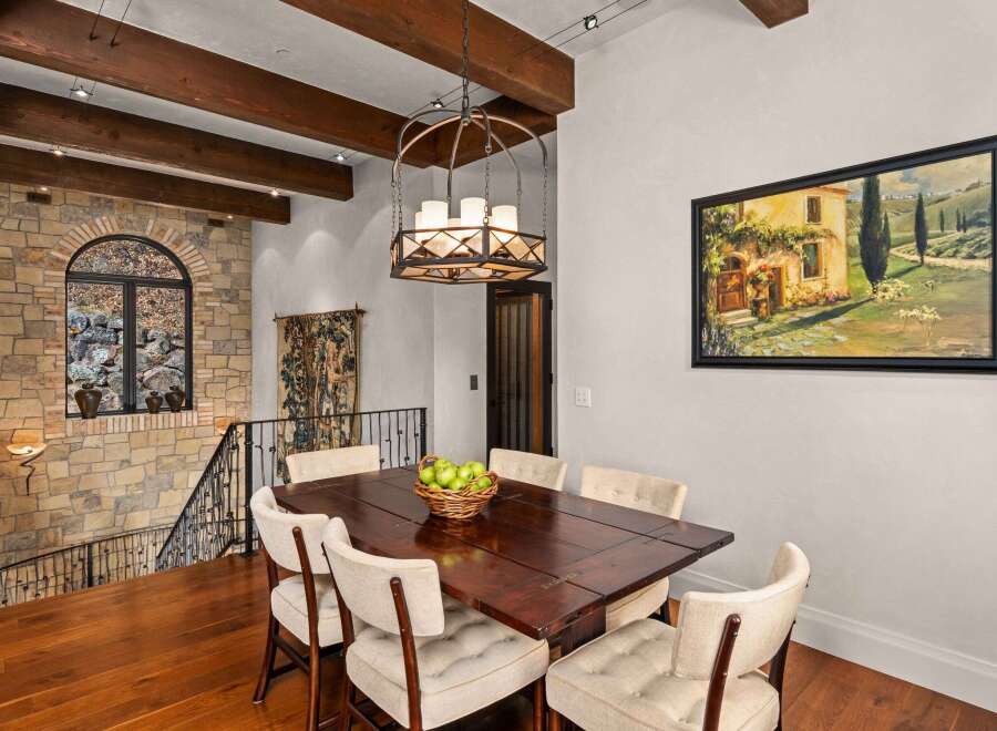 Step into luxury with this stunning dining area, featuring a rich, dark wood dining table and elegant upholstered chairs.