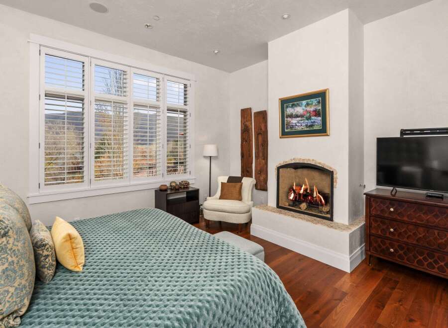 This luxurious bedroom features a cozy fireplace, perfect for relaxing on chilly evenings.