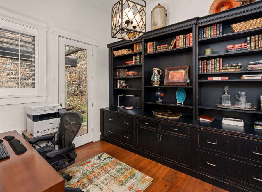 Step into this elegant home office, featuring a stunning built-in bookcase and ample storage.