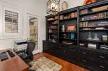 Step into this elegant home office, featuring a stunning built-in bookcase and ample storage.