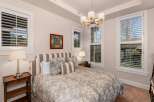This elegant bedroom showcases a blend of comfort and style, featuring a cozy bed adorned with patterned bedding and plush pillows.