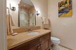 This luxurious bathroom features a stunning vanity with a natural stone countertop and a stylish sink.