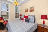 This cozy bedroom features a comfortable bed with a plaid comforter and decorative pillows, creating a warm and inviting atmosphere.