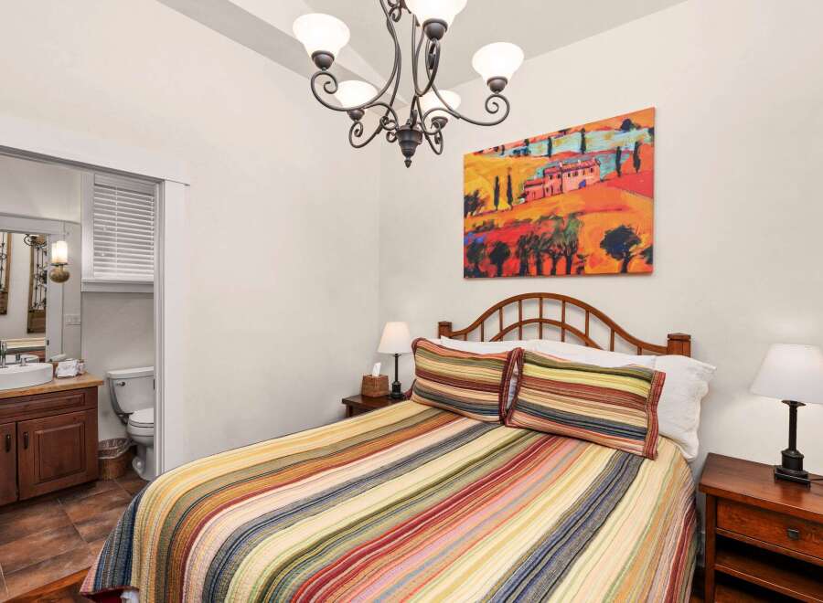 This charming bedroom features a cozy bed adorned with colorful striped bedding and pillows, creating a warm and inviting atmosphere.