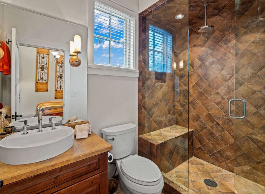 Step into luxury with this stunning bathroom featuring a spacious walk-in shower with a built-in bench and elegant tile work.