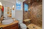 Step into luxury with this stunning bathroom featuring a spacious walk-in shower with a built-in bench and elegant tile work.