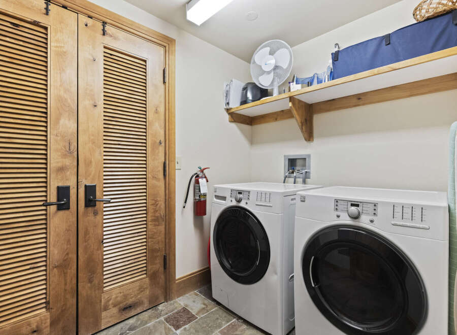 This laundry room features a modern design with a front-load washer and dryer.