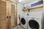 This laundry room features a modern design with a front-load washer and dryer.