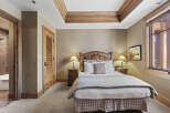 This cozy bedroom features a beautifully crafted wooden headboard and matching nightstands, creating a warm and inviting atmosphere.