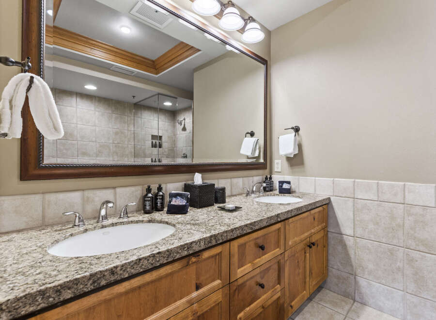 This stunning bathroom features a double vanity with a granite countertop, offering ample space for daily routines.