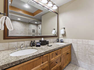 This stunning bathroom features a double vanity with a granite countertop, offering ample space for daily routines.
