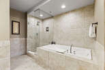 Indulge in luxury within this stunning bathroom, featuring a spacious soaking tub and a separate glass-enclosed shower.