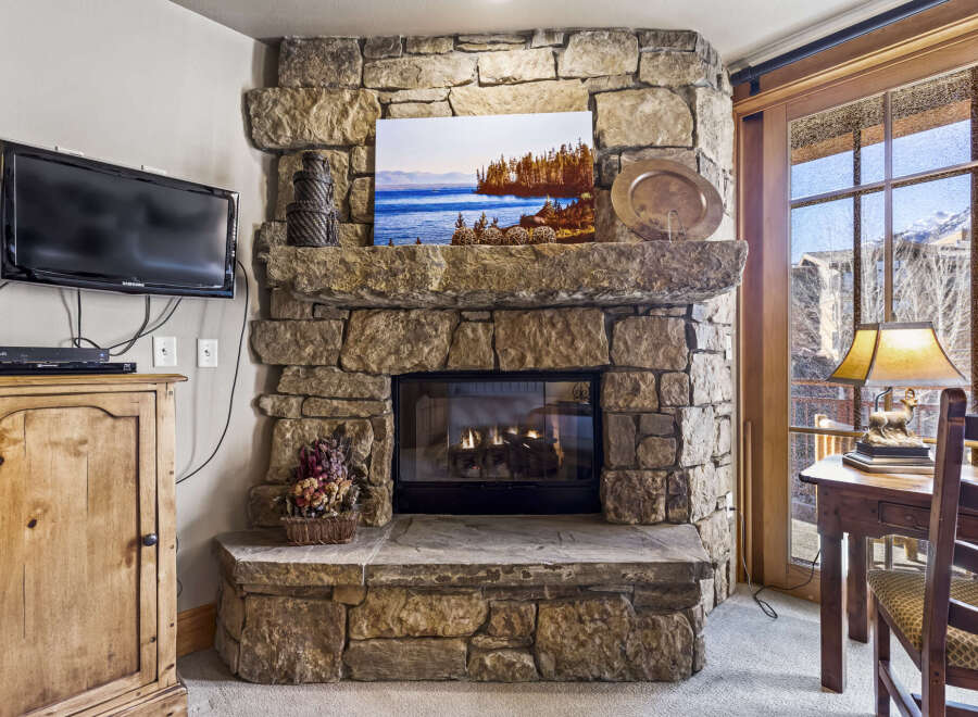This stunning property boasts a cozy living space centered around a beautiful stone fireplace, perfect for those chilly evenings.