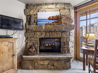This stunning property boasts a cozy living space centered around a beautiful stone fireplace, perfect for those chilly evenings.