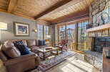 Step into luxury with this stunning living room featuring a cozy fireplace and a beautiful wooden ceiling.