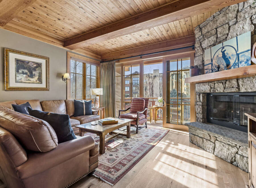 Step into luxury with this stunning living space, featuring a cozy fireplace and elegant wooden accents.