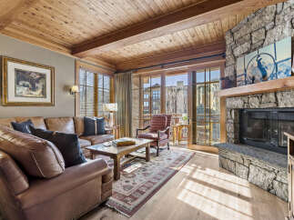 Step into luxury with this stunning living space, featuring a cozy fireplace and elegant wooden accents.
