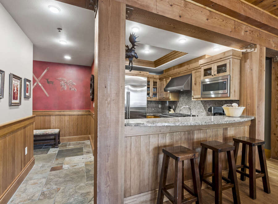 Step into rustic elegance with this stunning property, showcasing a beautifully designed kitchen with custom wood cabinetry and a sleek stainless steel refrigerator.
