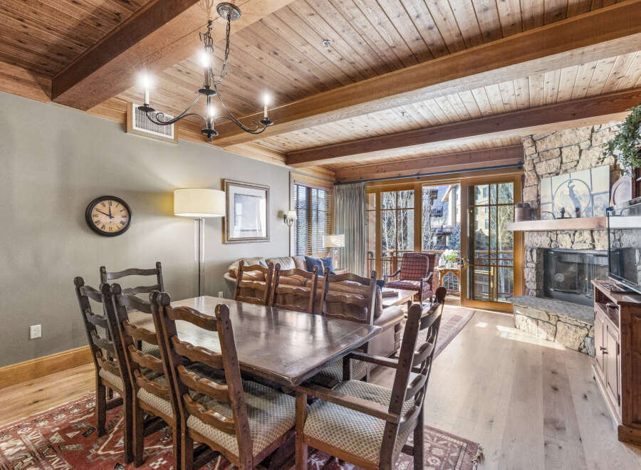 This stunning property features a spacious dining area with a rustic wooden table and chairs, perfect for hosting gatherings.