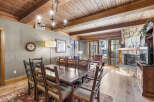 This stunning property features a spacious dining area with a rustic wooden table and chairs, perfect for hosting gatherings.
