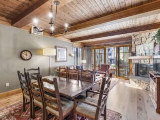 This stunning property features a spacious dining area with a rustic wooden table and chairs, perfect for hosting gatherings.