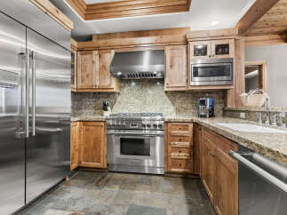 This stunning kitchen boasts top-of-the-line stainless steel appliances, including a refrigerator, range, and microwave.