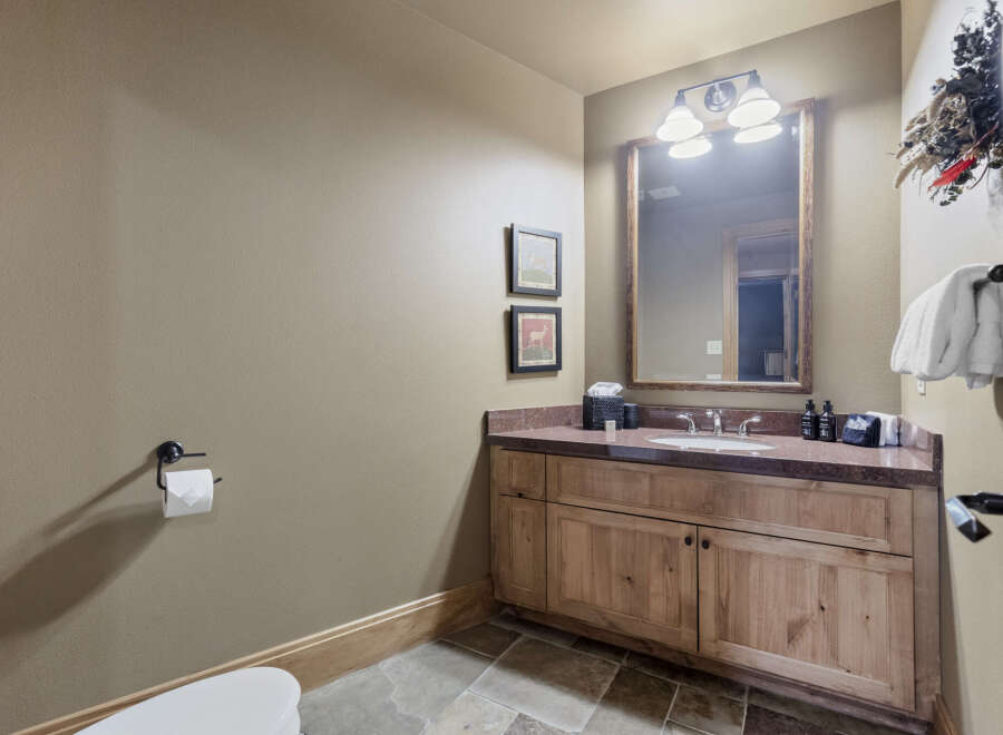 Step into this beautifully designed bathroom, featuring a rustic wooden vanity and a stylish countertop.
