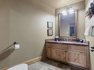 Step into this beautifully designed bathroom, featuring a rustic wooden vanity and a stylish countertop.