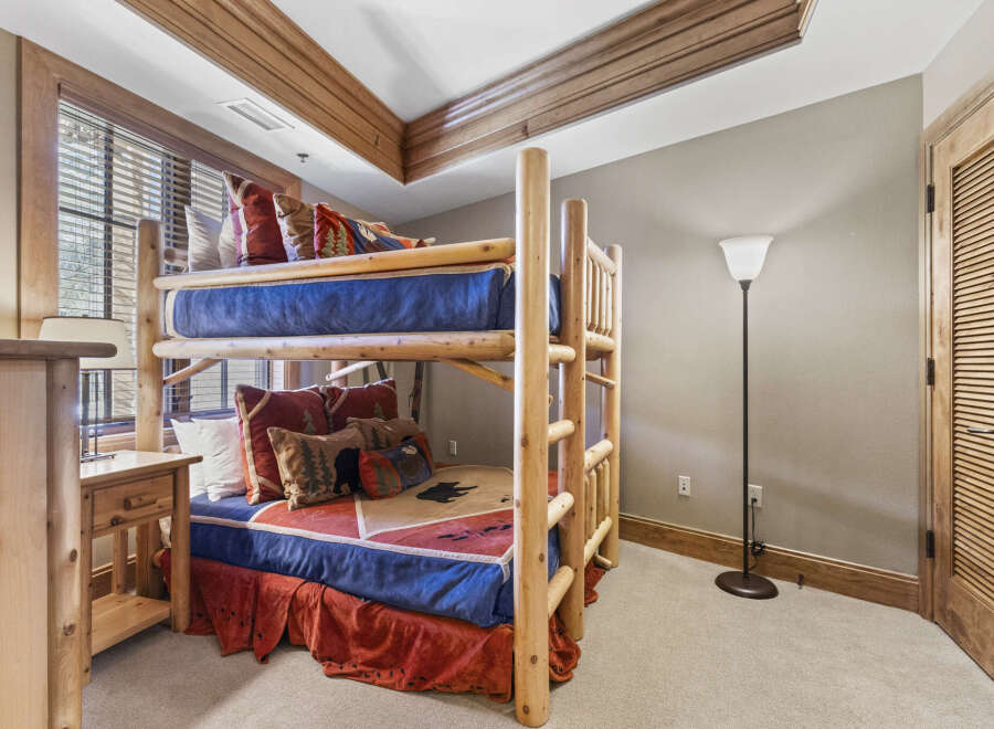This cozy bedroom features a rustic bunk bed, perfect for a vacation home or a kid's room.