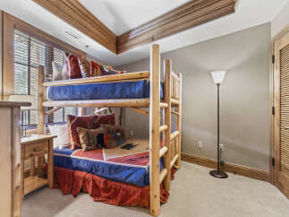 This cozy bedroom features a rustic bunk bed, perfect for a vacation home or a kid's room.