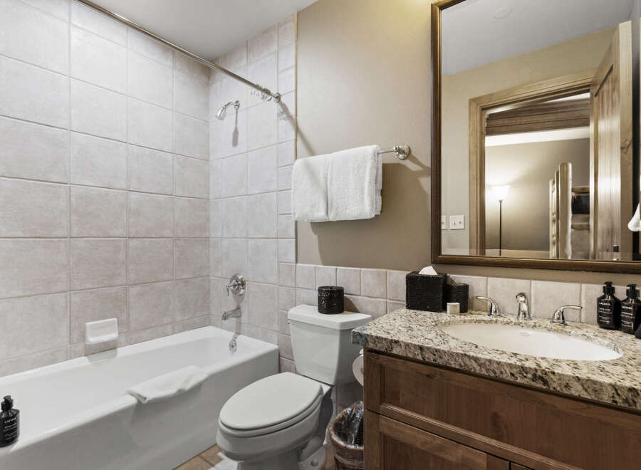 This beautiful bathroom features a modern design with a sleek vanity and a spacious bathtub.