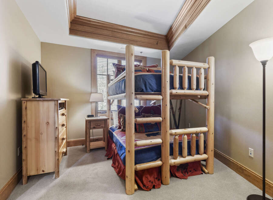 This charming bedroom features a rustic bunk bed, perfect for accommodating guests or family.