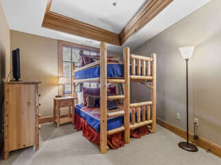 This charming bedroom features a rustic bunk bed, perfect for a cozy retreat.