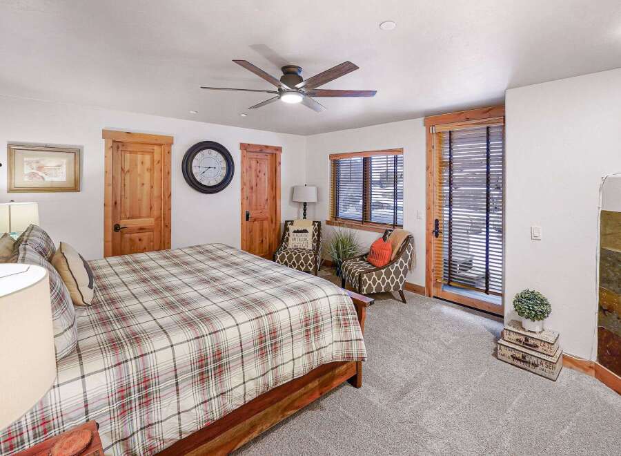 Step into this inviting bedroom, featuring a cozy bed adorned with a plaid comforter.