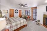 Step into this inviting bedroom, featuring a cozy bed adorned with a plaid comforter.