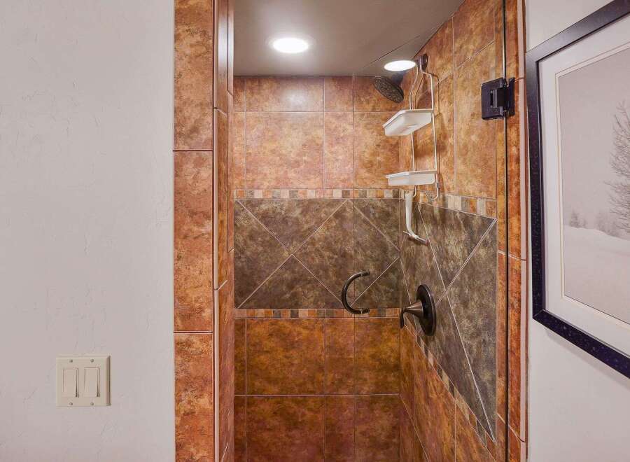 Step into luxury with this stunning bathroom featuring a beautifully tiled shower.