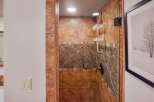 Step into luxury with this stunning bathroom featuring a beautifully tiled shower.