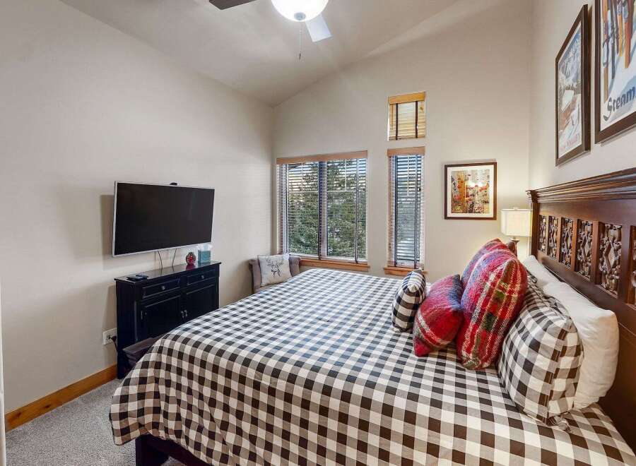 This cozy bedroom features a stylish black and white checkered bedspread, creating a welcoming atmosphere.
