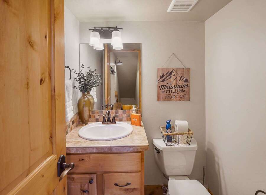 Step into this charming bathroom, featuring a rustic wooden vanity and a stylish sink.