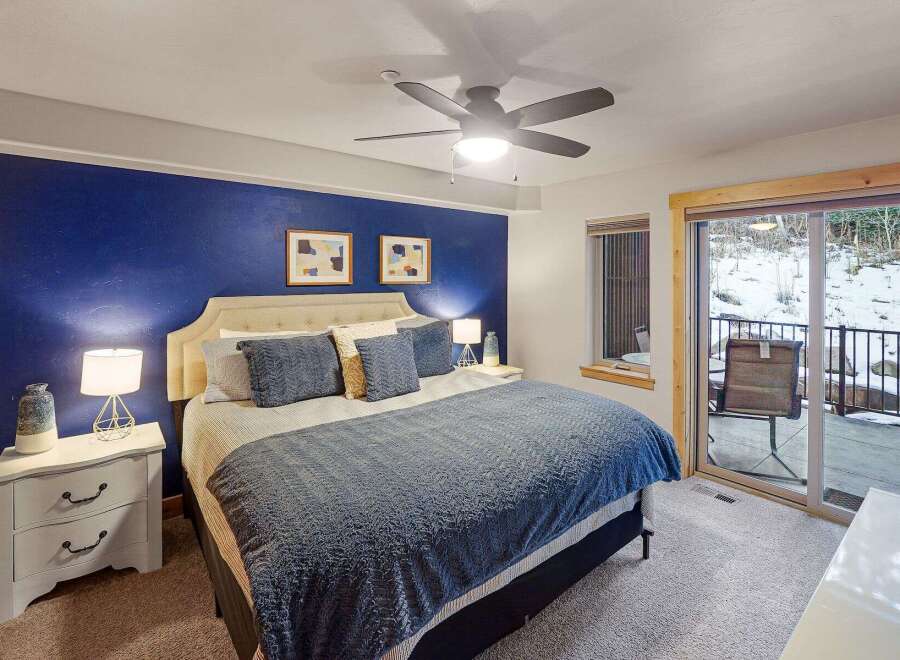 This stunning bedroom boasts a vibrant blue accent wall, creating a cozy and inviting atmosphere.