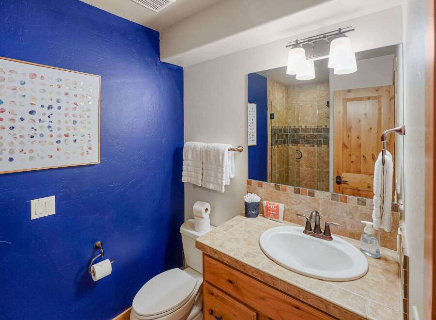 This stunning bathroom boasts a vibrant blue accent wall, creating a bold and inviting atmosphere.