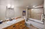This inviting bathroom features a well-lit vanity area with a large mirror and ample storage.
