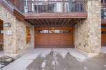 This stunning property boasts a beautiful stone exterior and a charming wooden garage door.