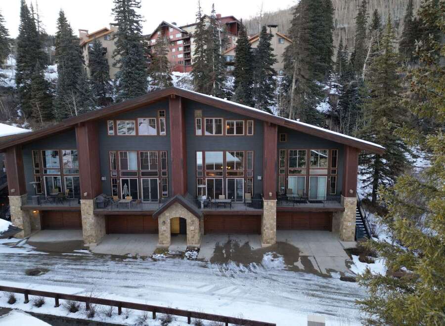 This stunning mountain home boasts a modern design with expansive windows that capture breathtaking views.