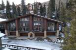 This stunning mountain home boasts a modern design with expansive windows that capture breathtaking views.