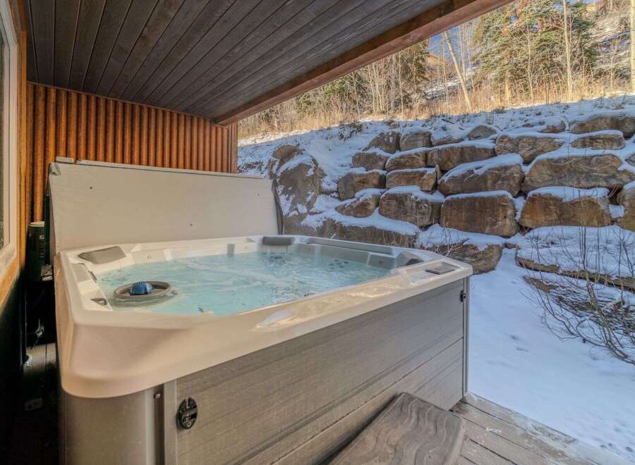 Relax and unwind in this luxurious hot tub, perfect for enjoying the serene winter landscape.