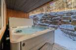 Relax and unwind in this luxurious hot tub, perfect for enjoying the serene winter landscape.