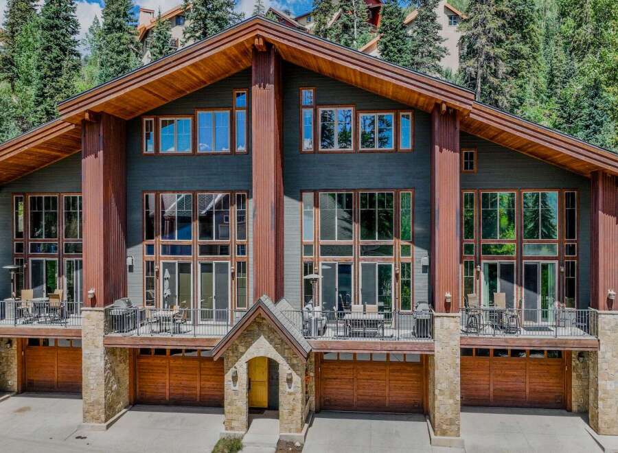 Experience luxury mountain living in this stunning multi-level home, featuring expansive windows that flood the interior with natural light and showcase breathtaking forest views.