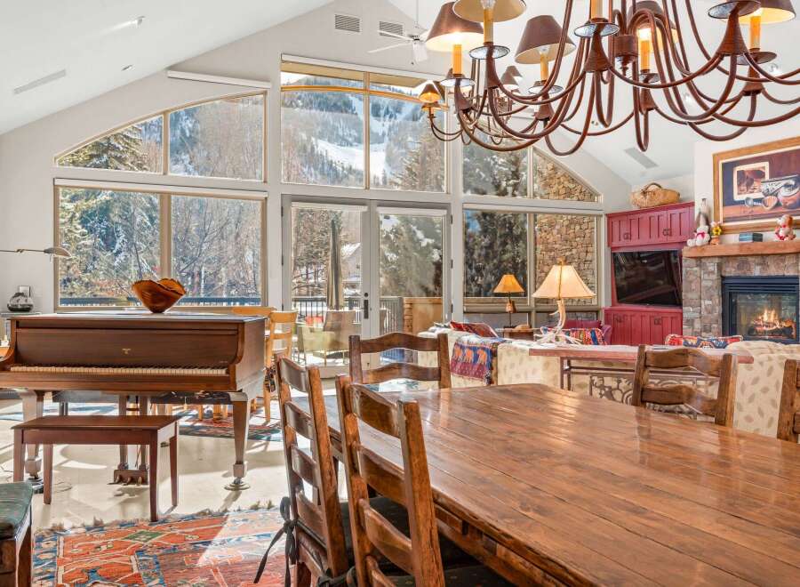 This stunning property boasts a spacious dining area with a large wooden table and chairs, perfect for hosting gatherings.