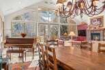 This stunning property boasts a spacious dining area with a large wooden table and chairs, perfect for hosting gatherings.